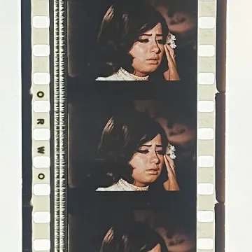 35mm film fragment depicting a woman in white.