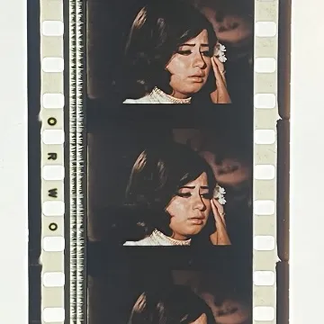 35mm film fragment depicting a woman in white.