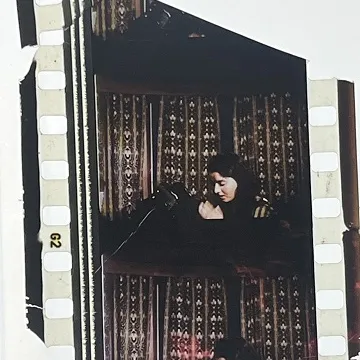 35mm film fragment depicting a woman praying.