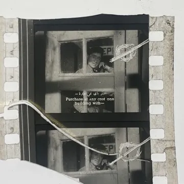35mm film fragment depicting a man talking on the phone.