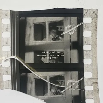 35mm film fragment depicting a man talking on the phone.