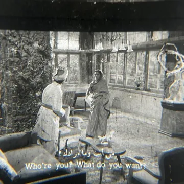 35mm film fragment depicting a woman talking with a man.