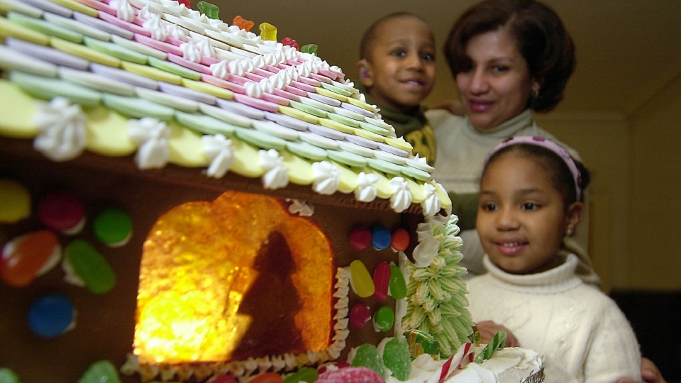 Photograph of people looking at a gingerbread house