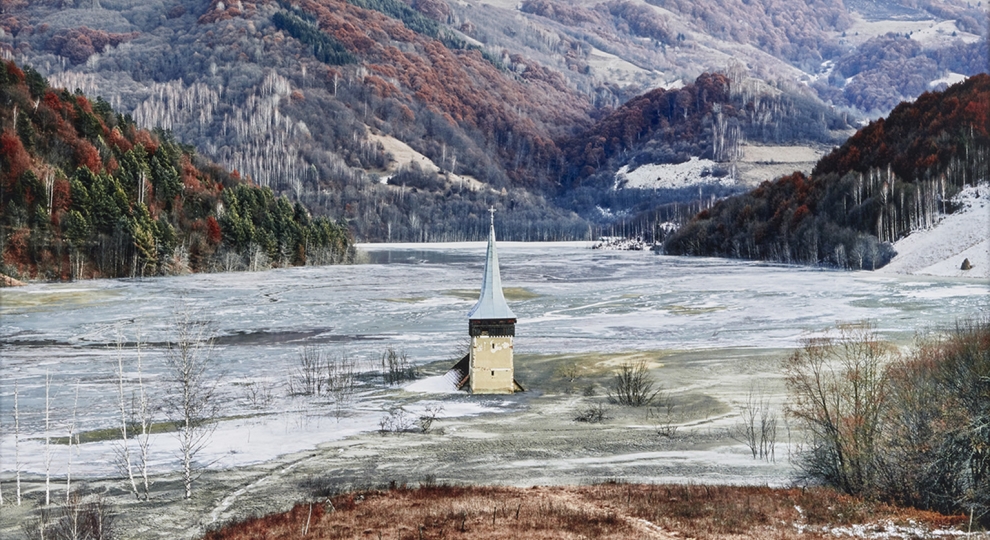 Photograph by Tamas Dezso depicting a church steeple emerging from ice in a valley