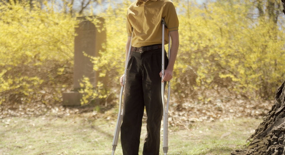 Portrait of a young person missing a shoe and is on crutches