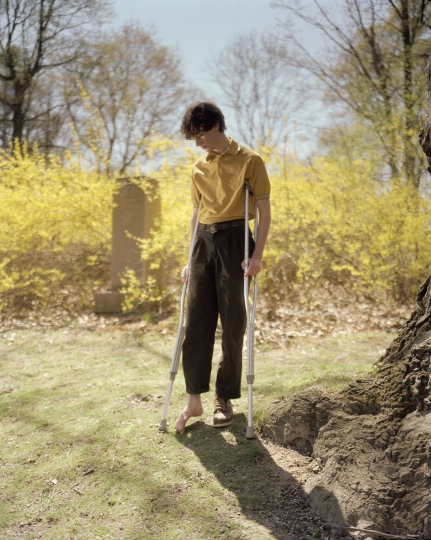 Portrait of a young person missing a shoe and is on crutches