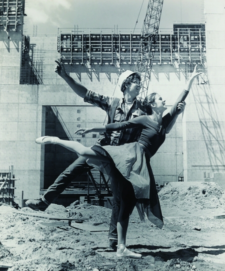 Ballet dancer posing with construction worker on work site, circa 1975, by Basil C. Levine