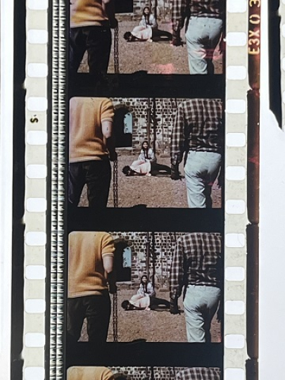 35 mm film fragment depicting a man on the ground with a woman.