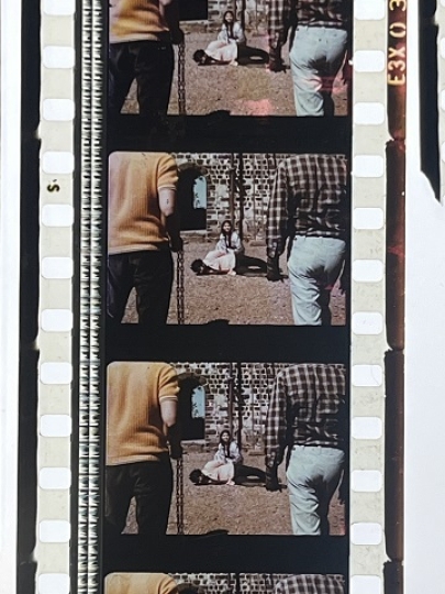 35 mm film fragment depicting a man on the ground with a woman.