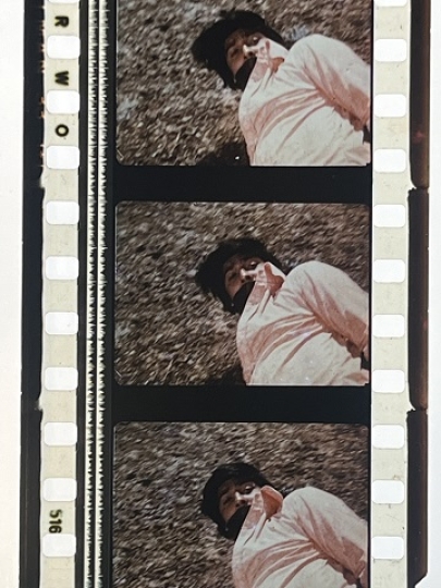 35mm film fragment depicting a man on the ground.
