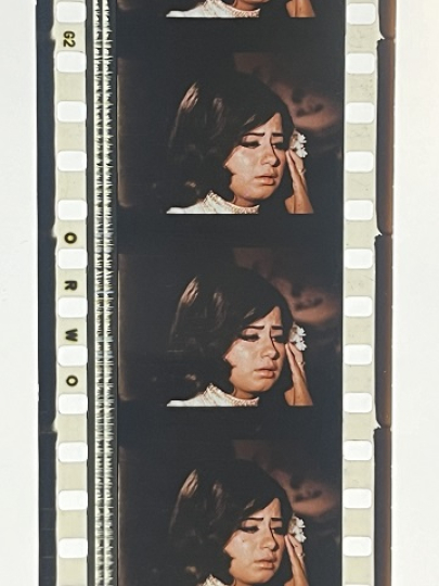 35mm film fragment depicting a woman in white.