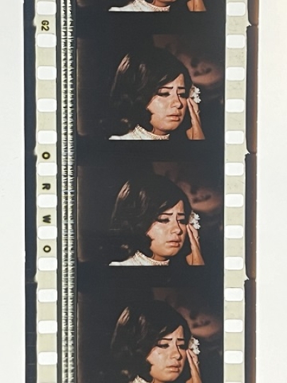 35mm film fragment depicting a woman in white.