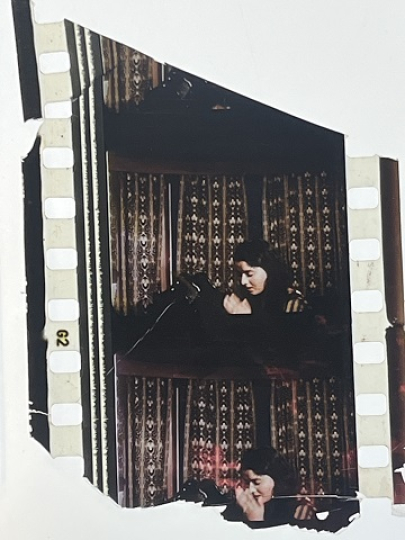 35mm film fragment depicting a woman praying.