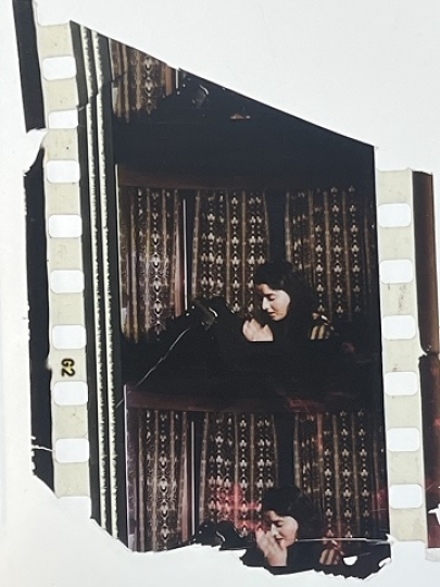 35mm film fragment depicting a woman praying.