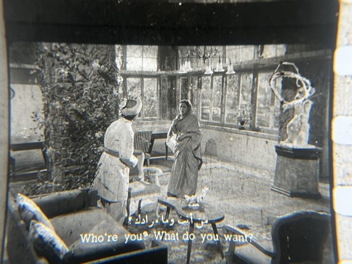 35mm film fragment depicting a woman talking with a man.