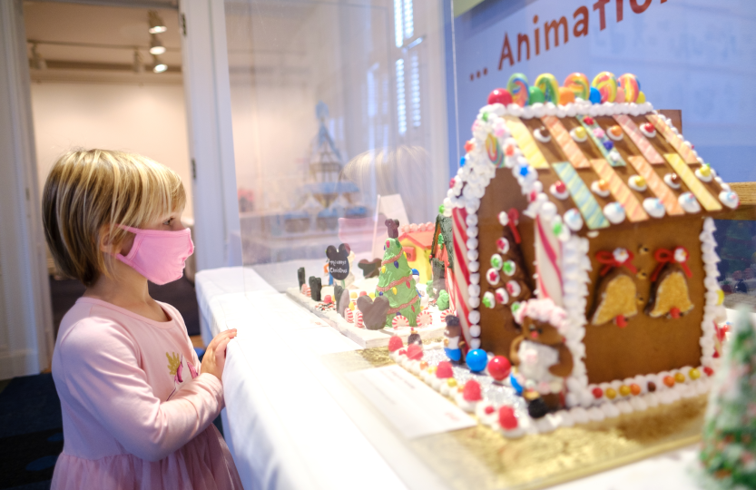 Girl looking at a gingerbread house