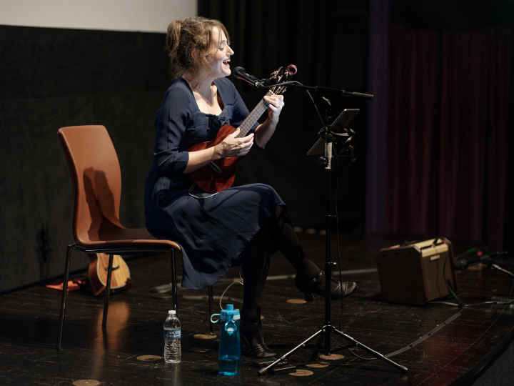 Maggie Paxson singing and playing ukulele in a performance at the George Eastman Museum