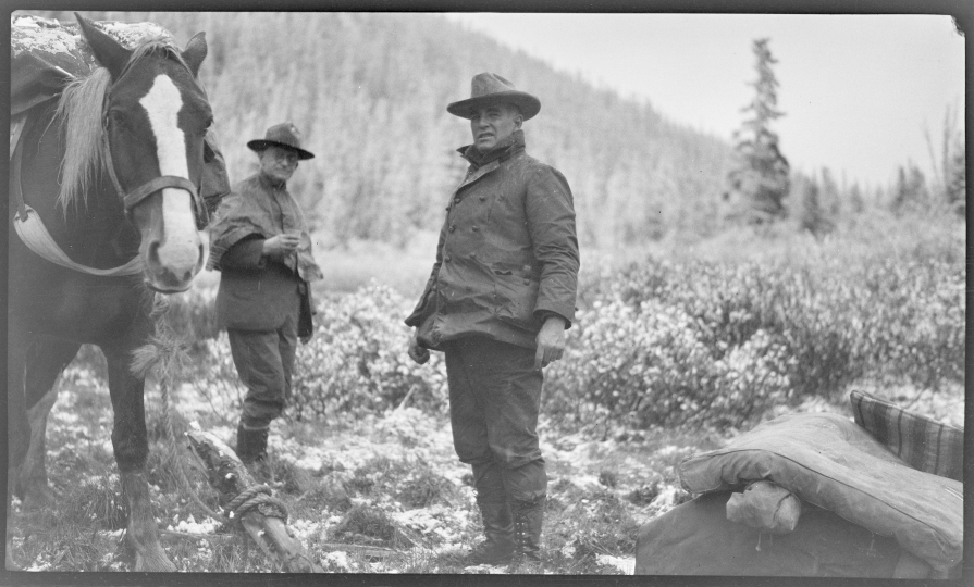George Eastman and another man dressed in warm clothes outside in Alaska, George Eastman is leading a horse