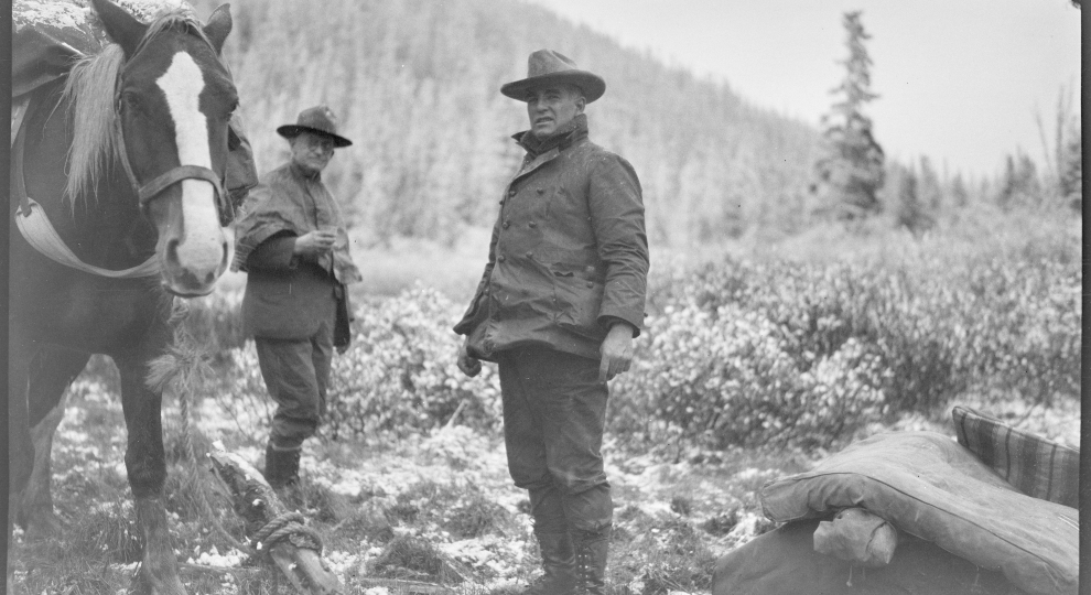 George Eastman and another man dressed in warm clothes outside in Alaska, George Eastman is leading a horse