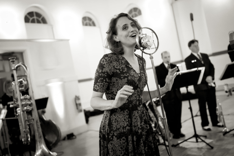 Photo of a young woman singing in a vintage microphone 