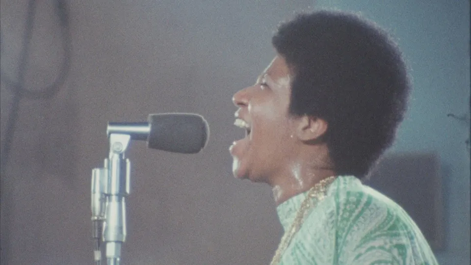 Still from the film Amazing Grace showing Aretha Franklin singing into a microphone