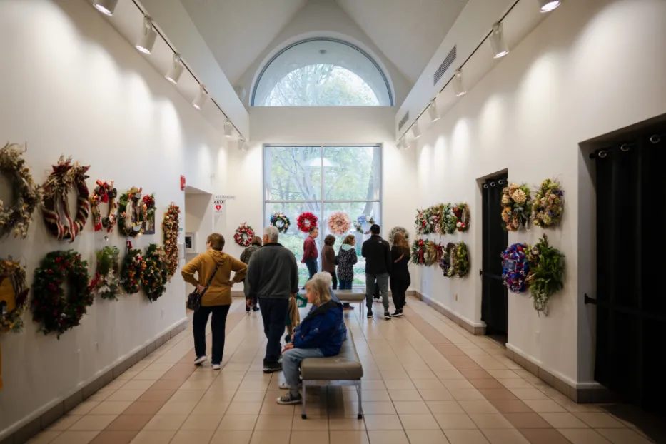 individuals in a hallway looking at a wreath display,undefined