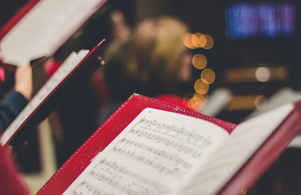 Photograph of individuals holding sheet music
