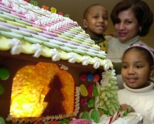 Photograph of people looking at a gingerbread house