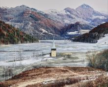 Photograph by Tamas Dezso depicting a church steeple emerging from ice in a valley