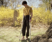 Portrait of a young person missing a shoe and is on crutches