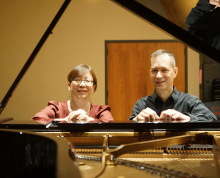 Bonnie Choi and Kevin Nitsch seated at a grand piano