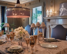 Dining table decorated with glassware, china, and small rabbit figurines, with a portrait of James Stewart and a large rabbit from the movie Harvey on the mantel in the background