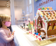 Girl looking at a gingerbread house