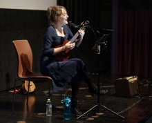 Maggie Paxson singing and playing ukulele in a performance at the George Eastman Museum