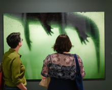Two adults looking at artwork on a gallery wall