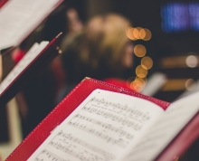 Photograph of individuals holding sheet music