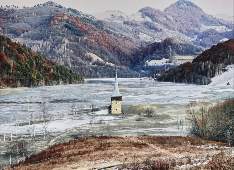 Photograph by Tamas Dezso depicting a church steeple emerging from ice in a valley