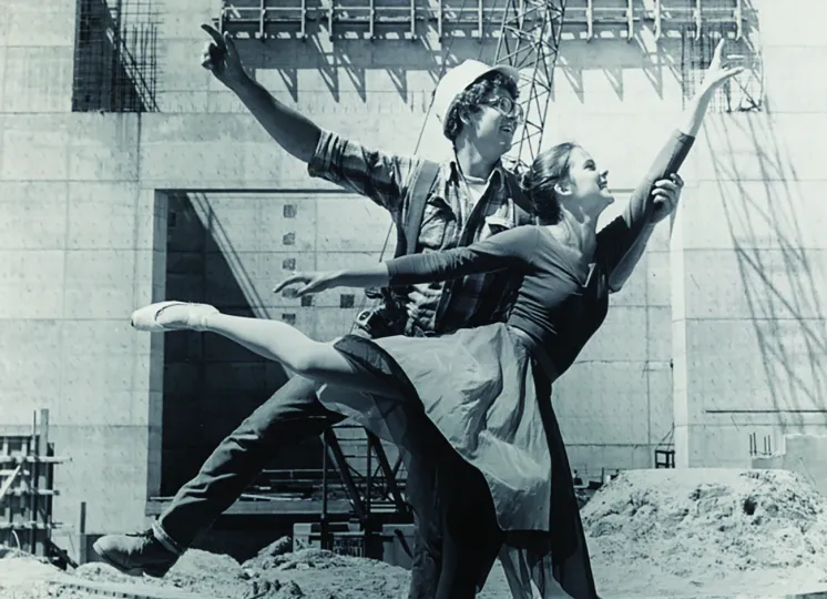 Ballet dancer posing with construction worker on work site, circa 1975, by Basil C. Levine
