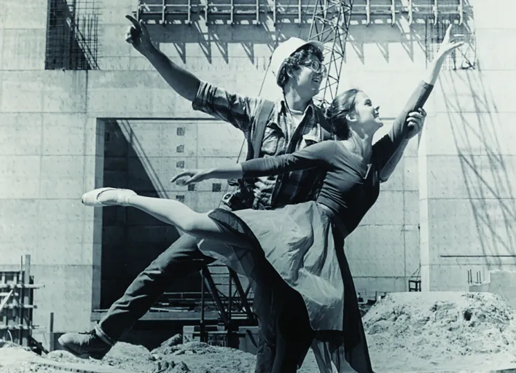 Ballet dancer posing with construction worker on work site, circa 1975, by Basil C. Levine