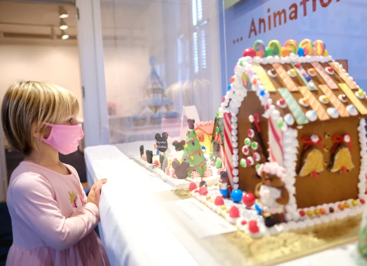 Girl looking at a gingerbread house