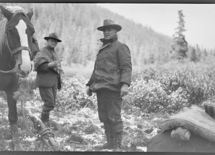George Eastman and another man dressed in warm clothes outside in Alaska, George Eastman is leading a horse