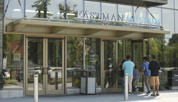 Family walking into the front doors of the Eastman Museum 