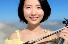 Headshot of Cindy Shang, facing camera and smiling and holding a violin