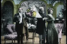 Painted original black and white film. Shows a surprised 19th c man holding flowers as an older man talks to a woman whose backs are turned.  