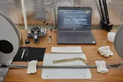 Work station showing film reel, processing tools, and a laptop showing the film