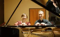 Bonnie Choi and Kevin Nitsch seated at a grand piano