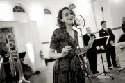 Photo of a young woman singing in a vintage microphone 