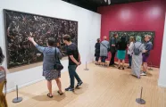 Individuals in the Woven exhibition looking at the photographs