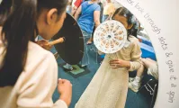 A mirror image of a child playing with a phenakistiscope in the Discovery Room at the George Eastman Museum 
